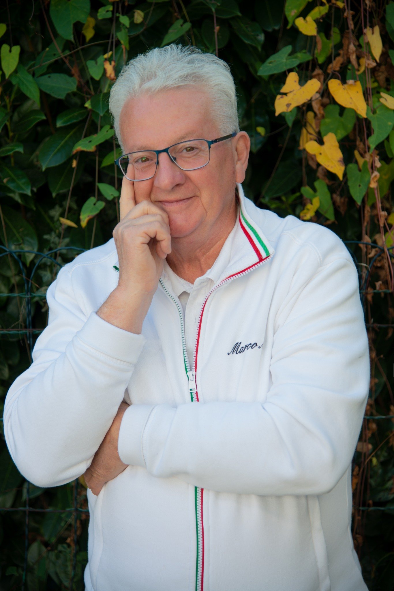 Marco Moroni, massoterapista del benessere, sorridente davanti a uno sfondo verde